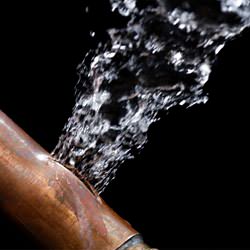 A bursting copper pipe in Maryville, with water gushing out.