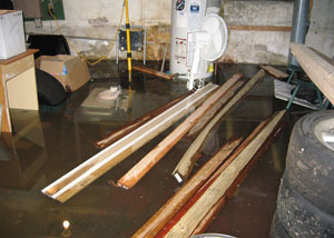 A severely flooding basement in Clinton, with lumber and personal items floating in a foot of water