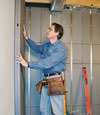 Insulated basement wall panels being placed against a concrete foundation wall in Crossville